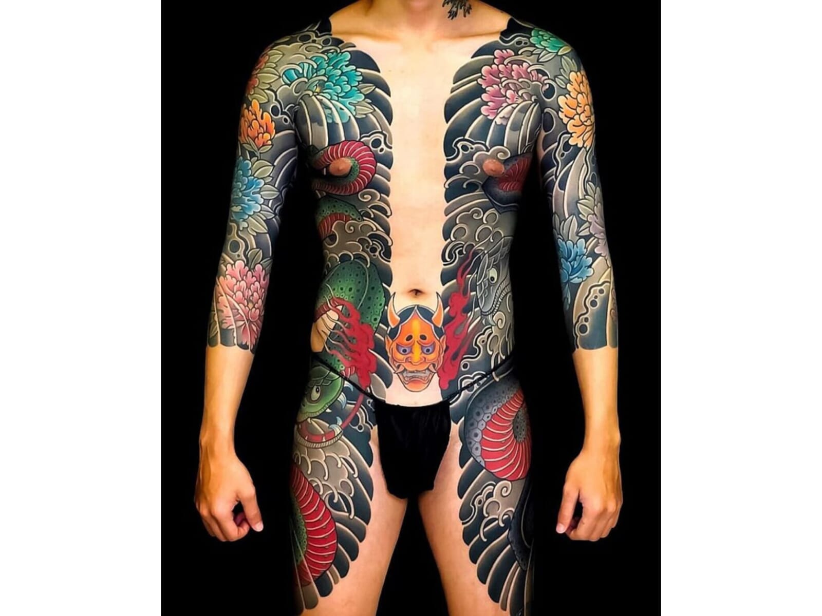 A tattoo of a hannya mask below the navel